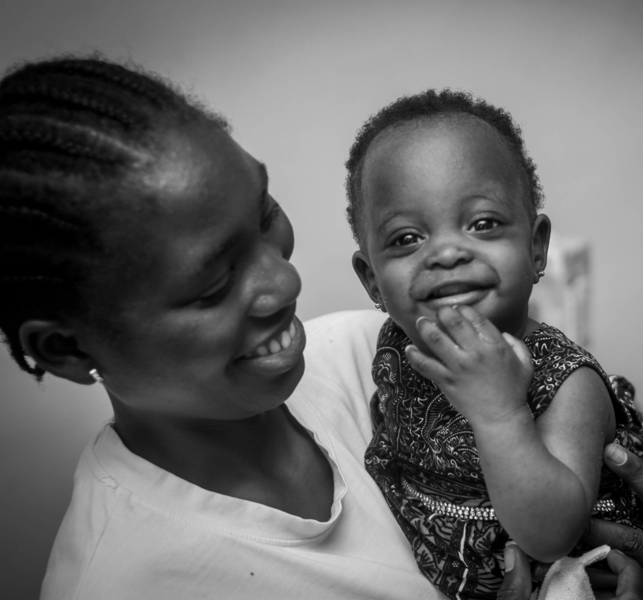 A Ugandan mother holding her smiling baby